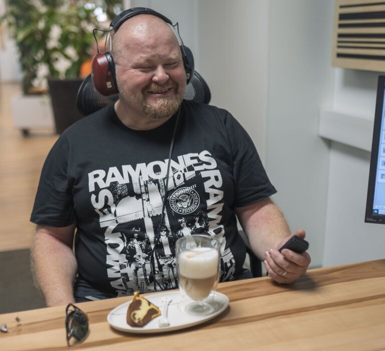 Kunde mit Kopfhörer bei Kaffee und Kuchen im Beratungsraum in Stainz